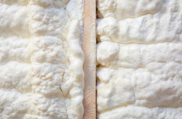 Close-up image of spray foam in-between beams of a house.