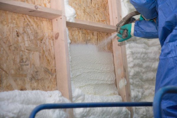A West Springfield Spray Foam contractor spraying foam insulation in a residential garage.