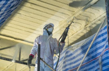 Worker from West Spring Field Spray Foam Insulation applying spray foam insulation to insulate a commercial property.